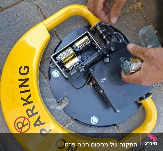 תיקון מחסום חניה עם סוללות על מדרכה